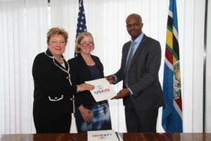 EAC Secretary General Amb. Liberat Mfumekeko exchanges signed copies of the five-year EAC-USAID Regional Development Objective Grant Agreement with Ms. Karen Freeman (USAID East Africa and the Chargé d’Affaires of the US Embassy in Tanzania, Ms. Virginia Blaser (centre).